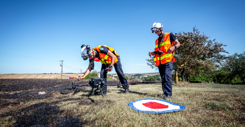 Deux sapeurs-pompiers s'entrainant avec un drone
